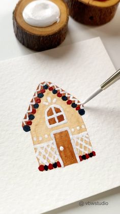 someone is painting a gingerbread house on paper