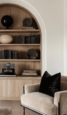 a living room filled with furniture and bookshelves next to a wall mounted book shelf