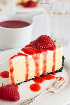 a piece of cheesecake on a plate with strawberries