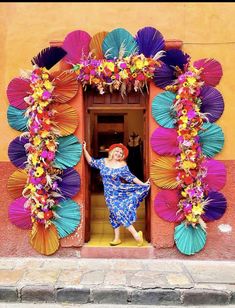 a woman standing in an open doorway surrounded by colorful umbrellas