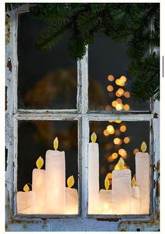 candles are lit in front of a window