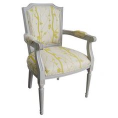 an upholstered chair with yellow and white fabric on the back, sitting against a white background