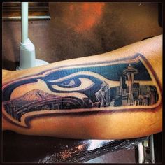 a tattoo on the arm of a man with an eye and cityscape in it