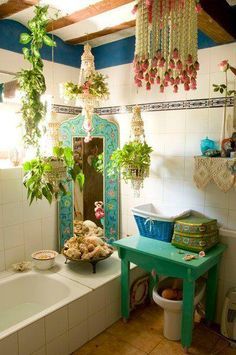 a bathroom with plants hanging from the ceiling and a bathtub in front of it