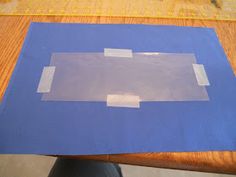 a piece of blue paper taped to a wooden table