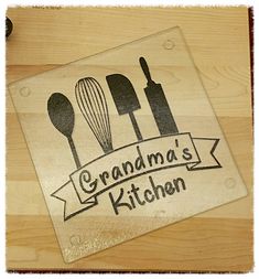 a glass cutting board with the words grandma's kitchen and utensils on it