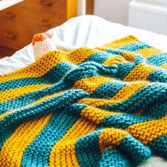 a crocheted blanket laying on top of a bed