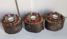 three wooden candlesticks decorated with holly and red berries