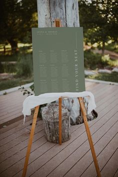 a sign sitting on top of a wooden floor next to a tree