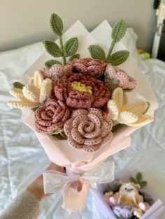 a bouquet of crocheted flowers on top of a bed