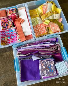 two plastic containers filled with different types of fabric and fabrics on top of a wooden table