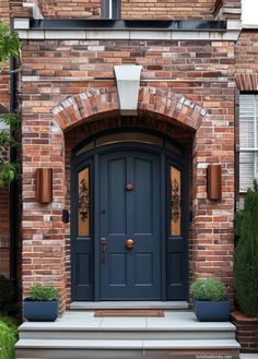 a blue front door with two planters on either side and an arch above it