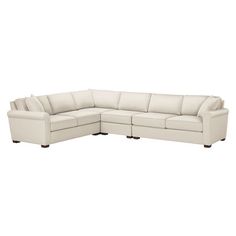 a white sectional couch sitting on top of a white floor