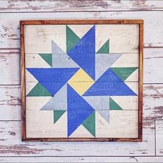 a wooden wall hanging with a blue and yellow star design on it's side