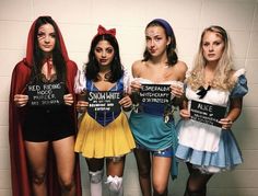 four women dressed up in costumes holding signs