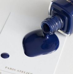 a bottle of blue liquid sitting on top of a piece of paper