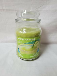 a jar filled with green liquid sitting on top of a white table