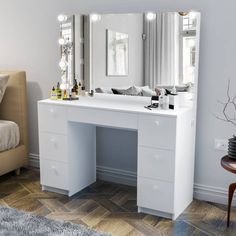 a white dressing table with lights on it and a mirror over the top, in front of a couch