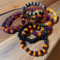 three bracelets with beads on a wooden table