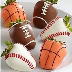 chocolate covered strawberries are arranged in the shape of footballs and basketball balls on a plate