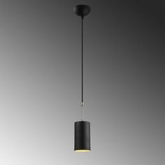 a black and white light hanging from a ceiling fixture in a room with gray walls