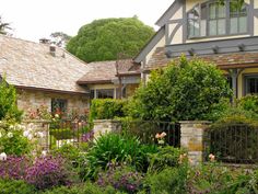 the house is surrounded by beautiful flowers and greenery