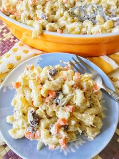 two plates filled with pasta and vegetables next to a casserole dish