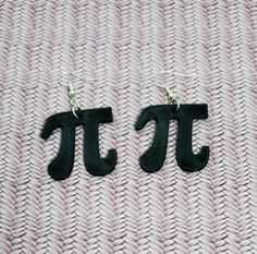 the letters j and t are made out of black fabric on top of a pink blanket