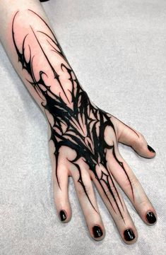 a woman's hand with black ink on it and some branches in the middle