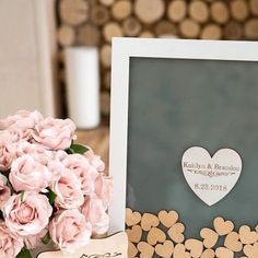 a bouquet of pink roses sitting on top of a table next to a framed photo