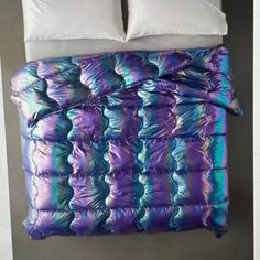 a bed with two pillows on top of it next to a pillow case and blanket