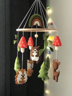 a mobile with various stuffed animals hanging from it's sides and mushrooms on the top