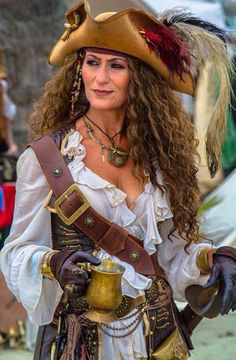 a woman dressed in pirate costume holding a bell