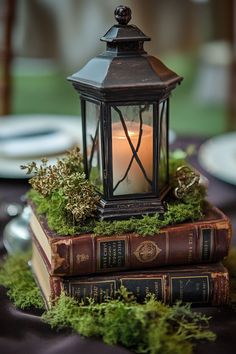 a candle is lit on top of two books that are sitting on a tablecloth