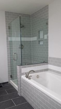 a white bath tub sitting inside of a bathroom next to a walk - in shower