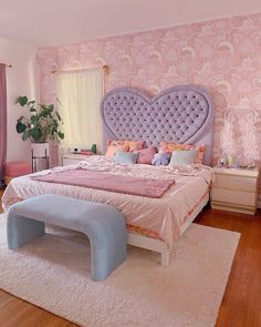 a bedroom with pink and purple walls, white rugs and a heart shaped bed