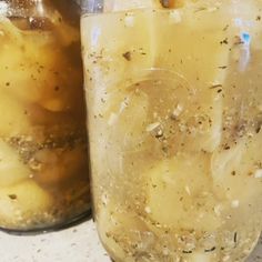 two jars filled with food sitting on top of a counter