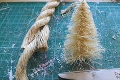 a pair of scissors sitting on top of a cutting board next to a piece of rope