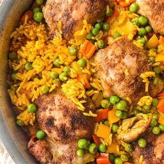 a pan filled with rice, peas and chicken