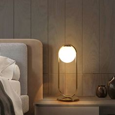 a lamp that is sitting on top of a night stand next to a bed and nightstand