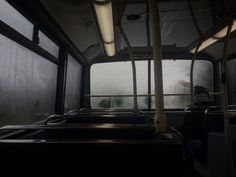 the inside of a bus with lots of windows and no people on it at night