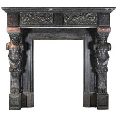 an antique fireplace with carved figures on it's sides and two candles in the middle