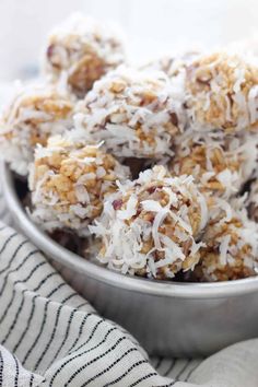 a metal bowl filled with coconut balls on top of a table