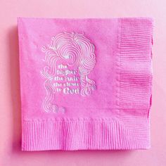 a pink napkin with a quote on it sitting on top of a pink tablecloth