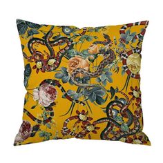 a yellow pillow with flowers and snakes on it