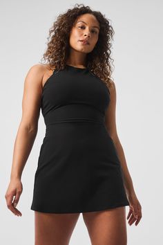 It’s a fresh ’90s spin on your favorite tennis dress, complete with a high neck, a fitted waist, and a short, swingy hem. But that’s not even the best part—see the open back and the chic trio of straps? Practical details include a built-in shelf bra with removable cups and built-in shorts with pockets for holding a tennis ball or two. Add some sneakers and get ready to serve. Black Mini Length Tennis Dress In Athleisure Style, Black Mini Length Athleisure Tennis Dress, Black Athleisure Mini Length Tennis Dress, Black Athleisure Mini Tennis Dress, Black Fitted Athleisure Dress, Black Mini Length Athleisure Dress, Black Athleisure Mini Length Dress, Black Athleisure Mini Dress, Chic Stretch Dresses For Workout