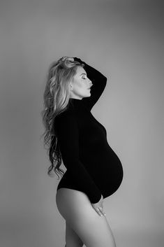 a pregnant woman is posing for a black and white photo with her long legs spread out