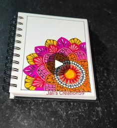 a spiral notebook with an image of a flower on the front and bottom cover that says jalis creations