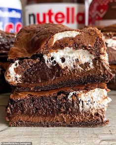 three chocolate brownies with marshmallows are stacked on top of each other