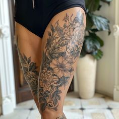 a woman's legs with tattoos and flowers on them